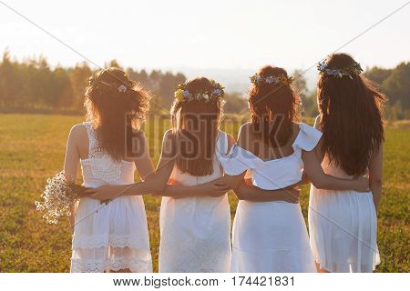 Beautiful blonde woman with flower wreath on her head. Beauty girl with flowers hairstyle. Girl in a summer forest. Fashion photo