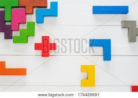 Concept of creative logical thinking. Different colorful shapes wooden blocks on white wooden background flat lay copy space. Geometric shapes in different colors top view. Abstract Background.