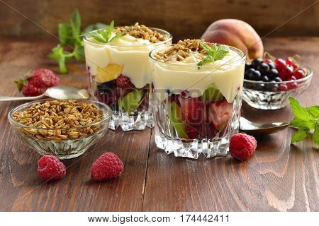 Dessert with fresh berries granola and custard in glasses