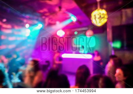 Blurred people inside disco club with colorful laser lights in background - Defocused image - Concept of nightlife with music entertainment - Original color bokeh - Warm vivid filter