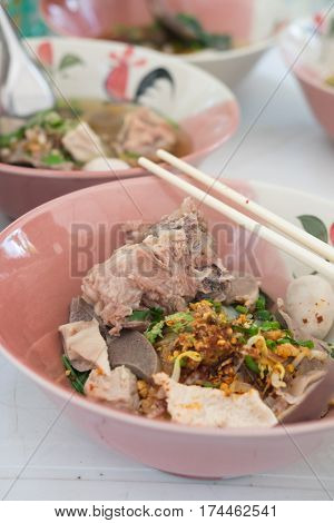 Close up bowl of Thai spicy noodles with pork and vegetables