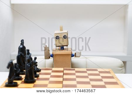 robot with hands sitting at the table playing a game of chess. Artificial Intelligence