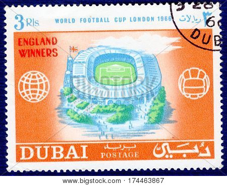 DUBAI - CIRCA 1966: Postage stamp printed in Dubai  with a picture of a stadium, with the inscription 