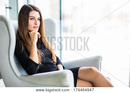 Attractive young woman sitting on a chair in a cafe