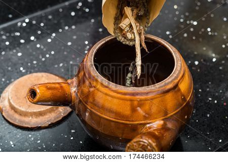 putting herbal to an enamel pot to decoct herbal medicine