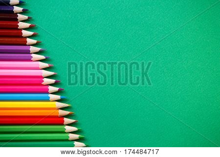 background from color pencils on green paper. Place for the text. Art and design. Drawing and painting. Artist. School and education.