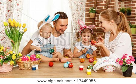 Happy easter! family mother father and children having fun paint and decorate eggs for holiday