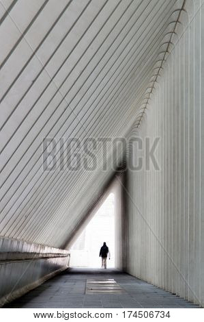 a man walk out at  end of a tunnel