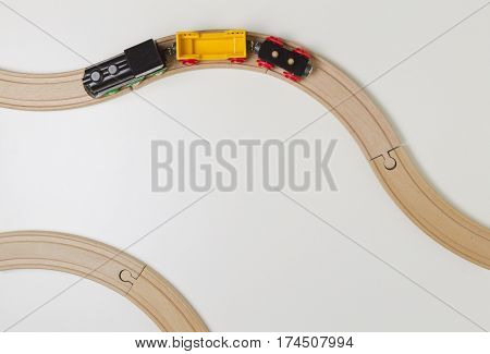 Toy train and wooden rails on white background. Top view.