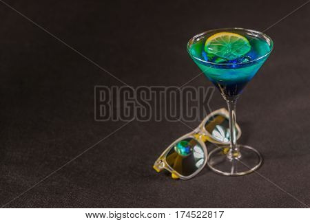 colored drink a combination of blue and green lemon martini glass yellow sunglasses party set