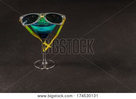 colored drink a combination of blue and green lemon martini glass yellow sunglasses party set