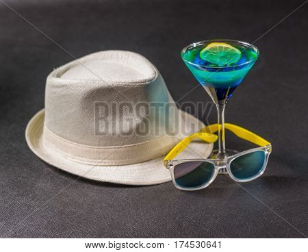 colored drink a combination of blue and green lemon martini glass yellow sunglasses white hat party set