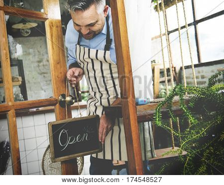 Man Hanging Open Sign by the Glass Window