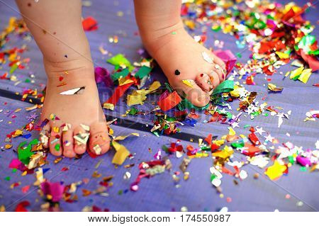 children's birthday party. bare feet are on the floor with confetti