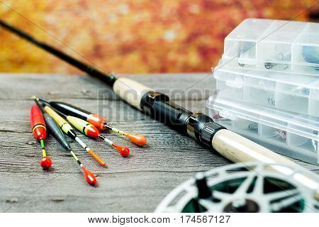 fishing rod with acsessories on the grey wooden table at autumn background