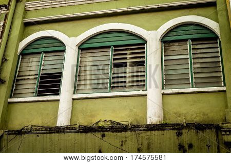 three weathered windows in asian backstreet, malaysia