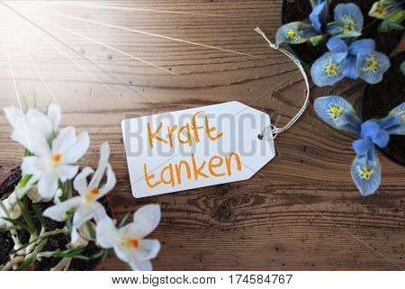 Sunny Label With German Text Kraft Tanken Means Relax. Spring Flowers Like Grape Hyacinth And Crocus. Aged Wooden Background