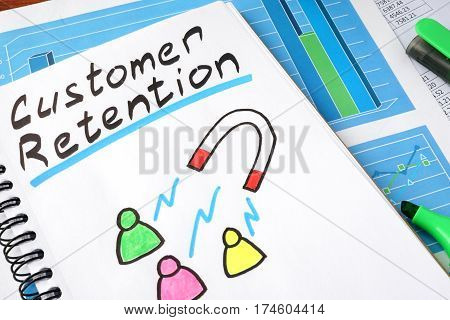 Customer retention written in a notebook and marker.