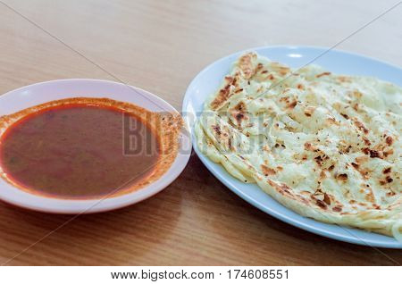 Roti canai or roti Prata with curry sauce.This is the famous authentic recipe used by the Indians in Malaysia.