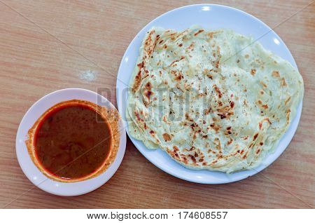 Roti canai or roti Prata with curry sauce.This is the famous authentic recipe used by the Indians in Malaysia.