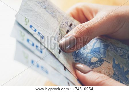 Hands holding money The cost is a fraction economy. and can be used in financial advertising.
