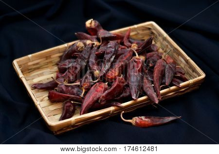 Dried red peppers are lying in a heap glitering with different shades of red