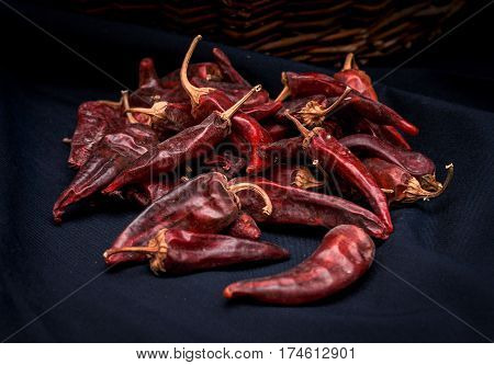 Dried red peppers are lying in a heap glitering with different shades of red