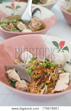 Thai Fusion Food dry noodle with pork in ceramic bowl with Thai style spice