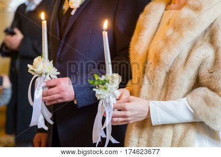 Bride holding candles. eremony in church. Traditional moment