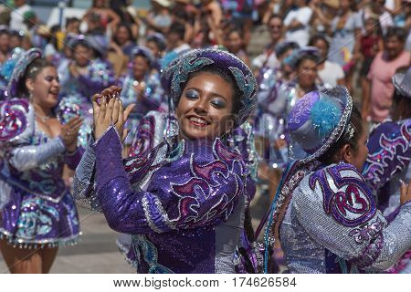 ARICA, CHILE - FEBRUARY 10, 2017: Female members of a Caporales dance group in ornate costumes performing at the annual Carnaval Andino con la Fuerza del Sol in Arica, Chile.