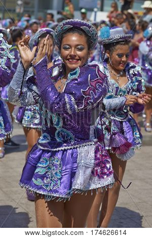ARICA, CHILE - FEBRUARY 10, 2017: Female members of a Caporales dance group in ornate costumes performing at the annual Carnaval Andino con la Fuerza del Sol in Arica, Chile.