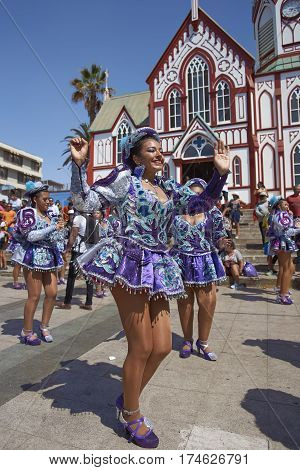ARICA, CHILE - FEBRUARY 10, 2017: Female members of a Caporales dance group in ornate costumes performing at the annual Carnaval Andino con la Fuerza del Sol in Arica, Chile.