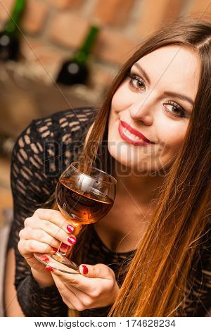 Woman Tasting Wine In Rural Cottage Interior