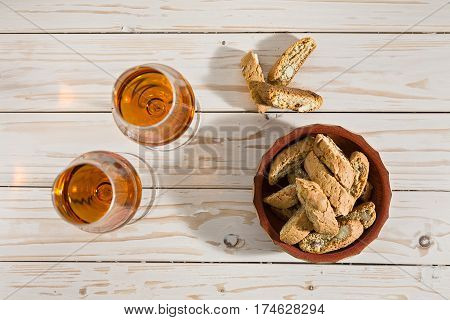 Italian cantucci biscuits and two glasses of vin santo wine on a table seen from above