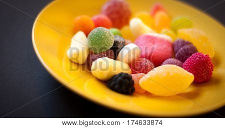 colored fruit candies on a yellow plate