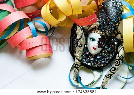carnival mask in the middle of colored streamers