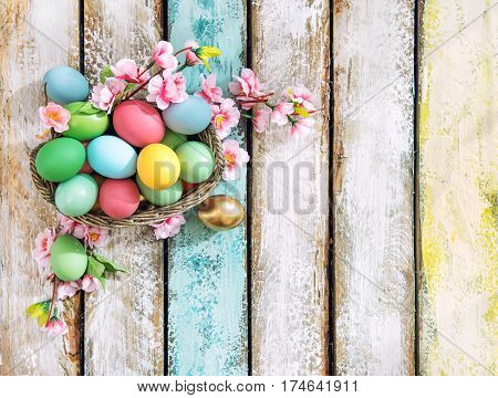 Easter eggs with flower decoration on wooden background. Vibrant colors. Vintage style toned pisture