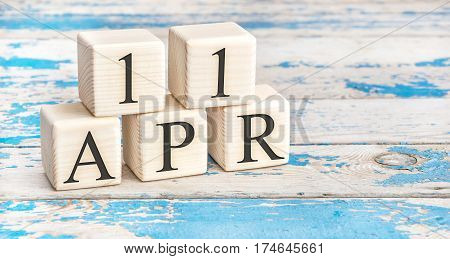 April 11Th. Wooden Cubes With Date Of 11 April  On Old Blue Wooden Background.