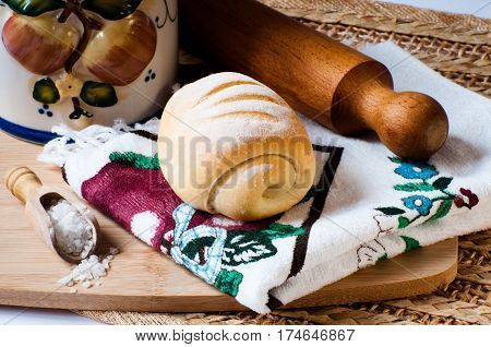 kamut bread on a kitchen cloth near salt and a rolling pin