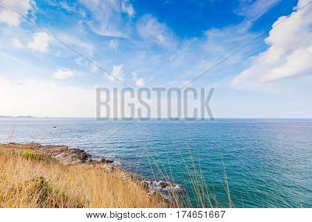 Beautiful seascape with rocks and meadow in cloudy blue sky at Khao Leam Ya National Park Rayong province Thailand