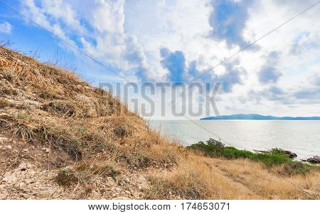 Beautiful seascape with rocks and meadow in cloudy blue sky at Khao Leam Ya National Park Rayong province Thailand