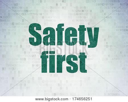 Protection concept: Painted green word Safety First on Digital Data Paper background