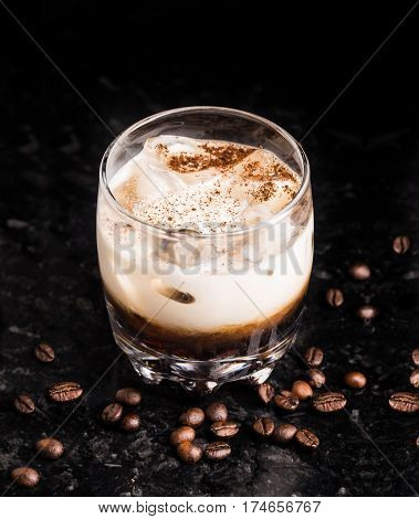 White russian cocktail with coffee beans on a marble table