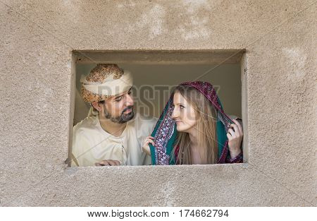 A woman in traditional omani dress in an abondoned village in a desert