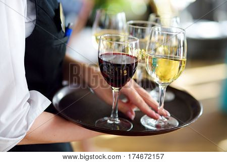 Waitress Holding A Dish Of Champagne And Wine Glasses At Festive Event