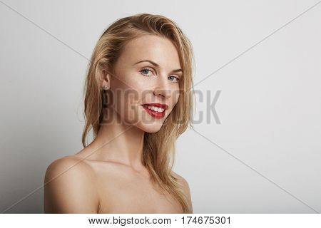 Portrait of beautiful young woman with blonde hair wearing red lipstick.