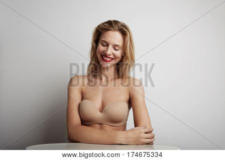 Portrait of beautiful young woman with blonde hair wearing nude bra.