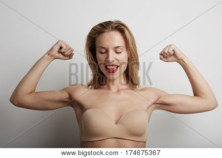 Portrait of beautiful young woman with blonde hair wearing nude bra.