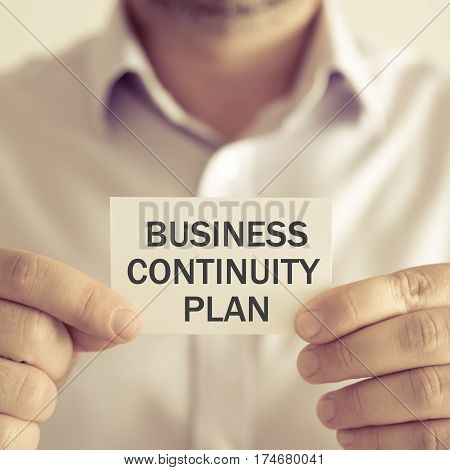 Businessman Holding Business Continuity Plan Message Card