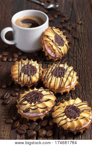 Coffee cup and shortbread cookies with cream and chocolate on old wooden table